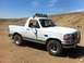 1994 Ford Bronco - This white Ford Bronco is parked in a dry, dusty area under a clear blue sky.