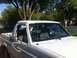 1994 Ford Bronco - This white Ford Bronco is viewed from the front passenger side, revealing its side mirror and door.