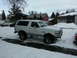 1994 Ford Bronco - A white Ford Bronco is parked on a snowy street in front of houses.