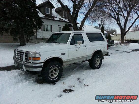 White 1994 Ford Bronco with brush guard parked in snow