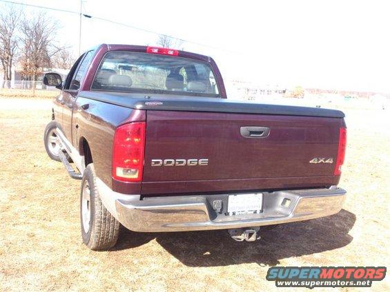 Rear view of a maroon Dodge 4x4 pickup truck with a bed cover