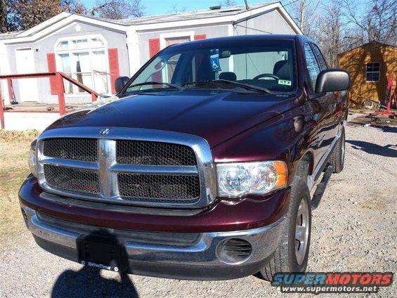maroon Dodge Ram pickup truck parked outside a house