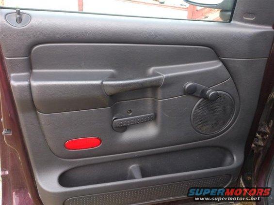 Driver's side door panel interior with manual window crank and speaker grille