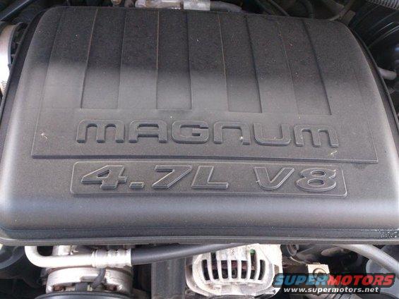 Engine cover with "MAGNUM 4.7L V8" embossed. Alternator visible below
