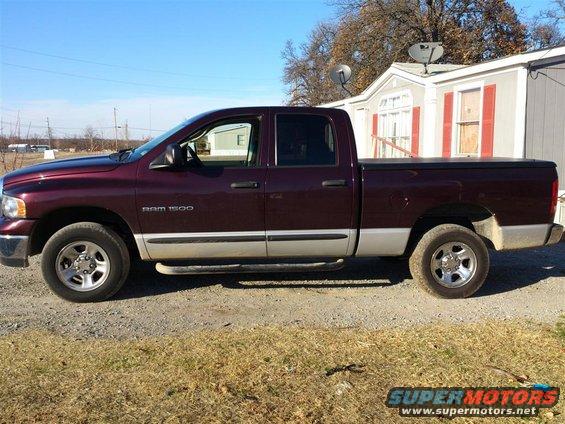 Maroon Dodge Ram 1500 pickup truck parked next to a mobile home