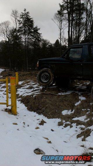 1995 Ford Bronco on snowy terrain near a yellow gate