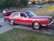 1984 Lincoln Town Car - A red sedan with a vinyl roof sits on a driveway next to a red minivan.