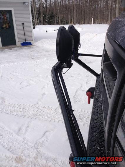 close-up of off-road lights mounted on a vehicle's bumper in the snow