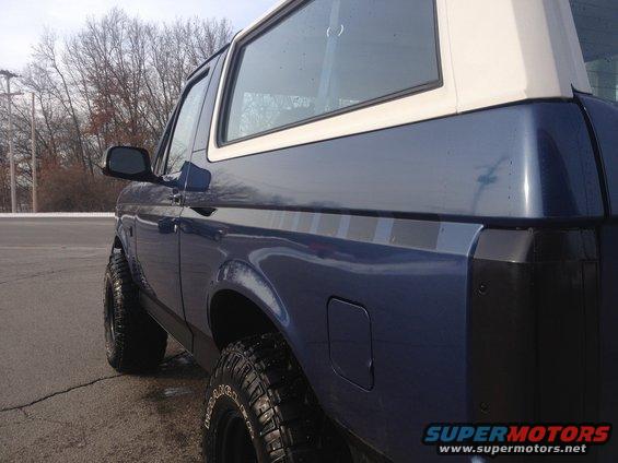 Blue SUV with white roof, side view. 1996 Ford Bronco