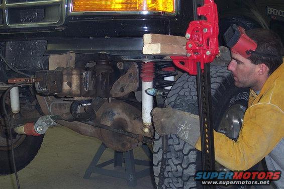 1996 Ford Bronco front suspension being worked on with a Hi-Lift jack