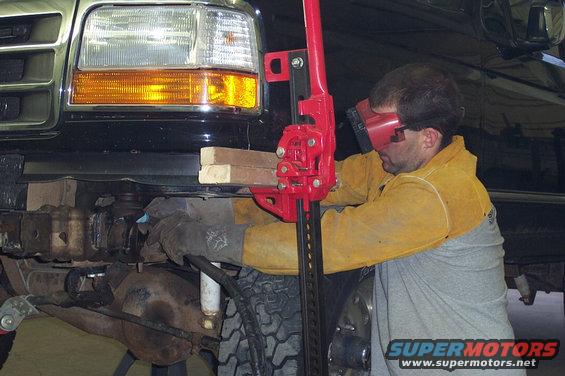 1996 Ford Bronco front end being lifted by a Hi-Lift jack for modification