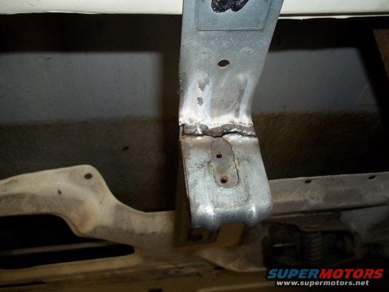 Welded metal bracket on underside of vehicle