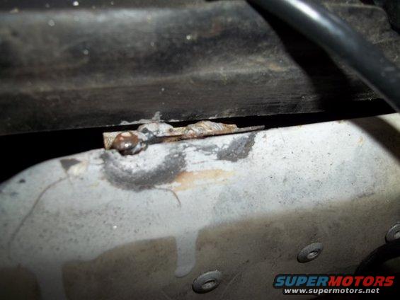 Rusted metal bracket with wire attached, close-up view