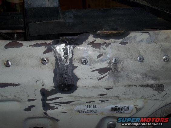 White metal panel with visible welds and bolt heads