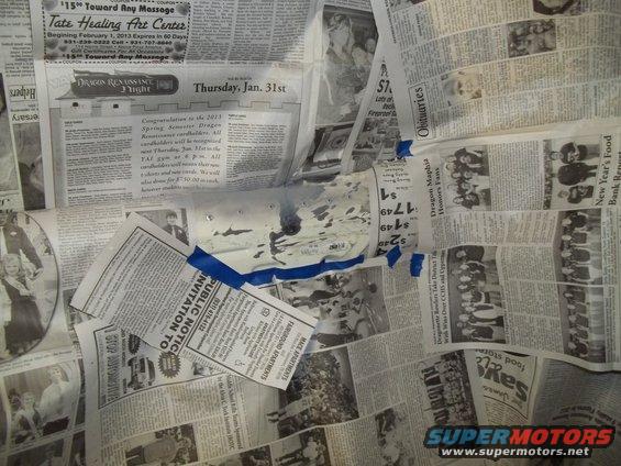 White car part taped to newspaper