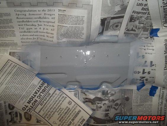 Underside of a vehicle part covered in newspaper for protection