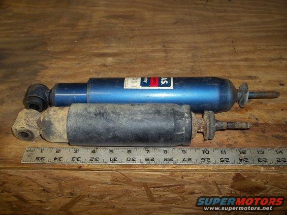 Blue and black shock absorbers with ruler for scale