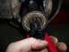 1990 Ford Bronco - Close-up of a wheel hub assembly with snap ring pliers in use.