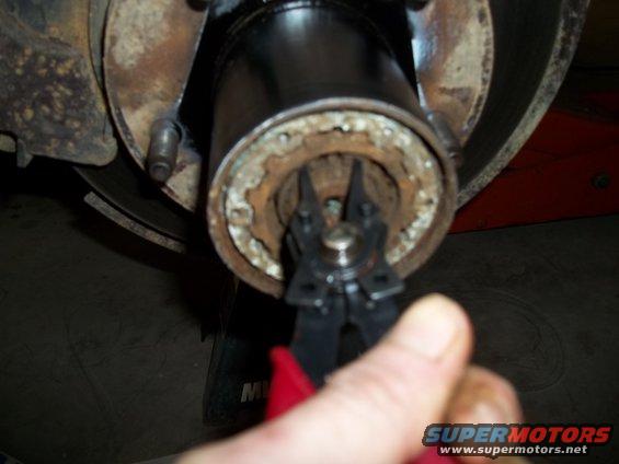 Wheel hub with snap ring pliers removing a snap ring