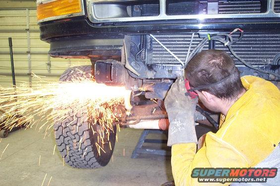 1996 Ford Bronco front end being modified with a grinder, sparks flying