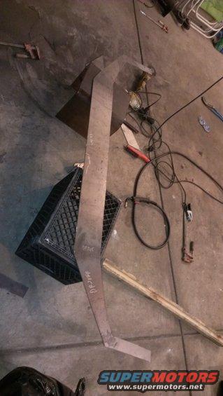 Bent metal piece with 'DRIVER' handwritten on it, lying on concrete floor next to tools and a plastic crate