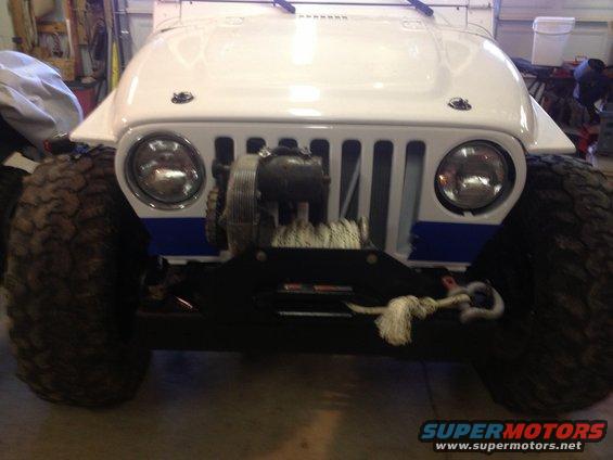 Front view of a white 2000 Jeep TJ with large tires and a winch mounted on the bumper