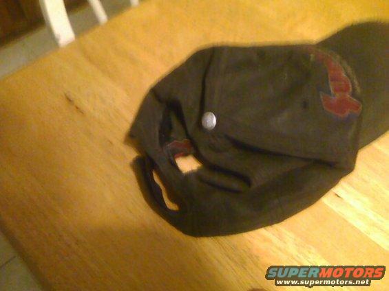 Dark baseball cap with a red logo on a wooden table