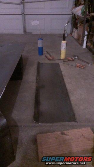 Sheet metal and two propane torches on a concrete floor in a garage