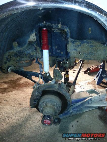 Front suspension and wheel hub assembly with red-topped shock absorber