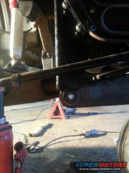 Close-up of vehicle suspension and frame with jack stands and a floor jack