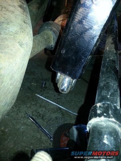 Close-up of vehicle suspension parts with a cutting tool nearby