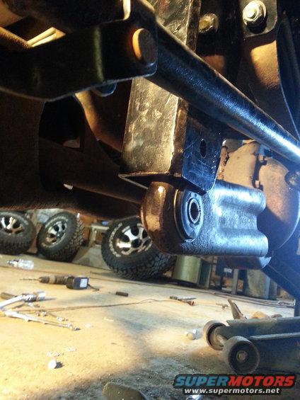 Close-up of suspension parts with tires visible in background