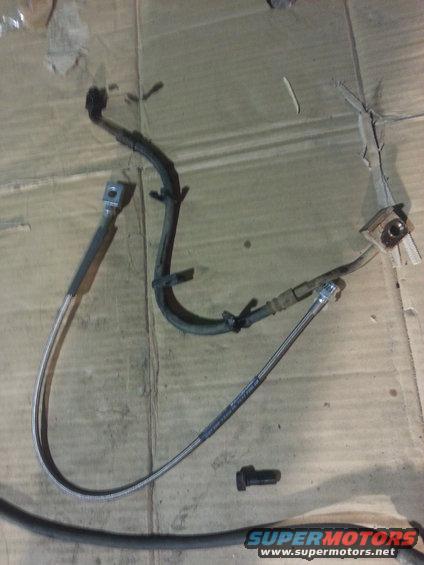 brake hoses and a bolt on a cardboard surface