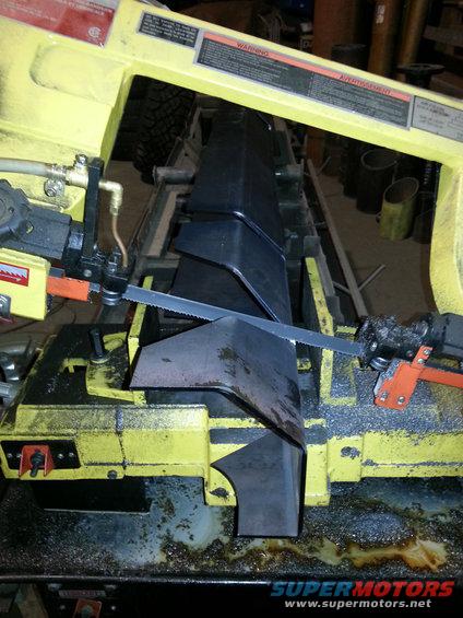 Metal parts being cut on a band saw