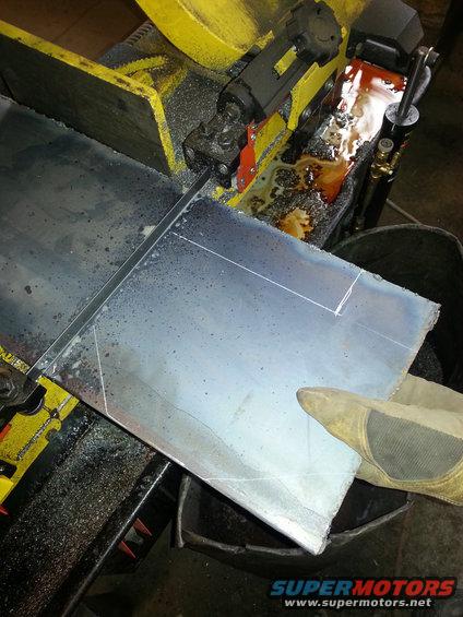 Metal sheet being cut by a band saw