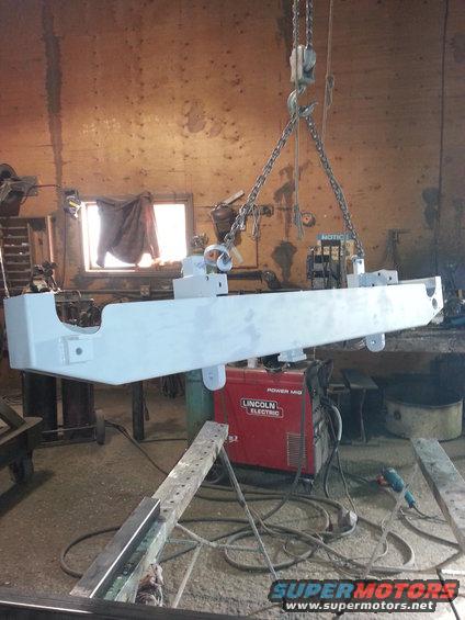 Painted frame hanging from chains in workshop
