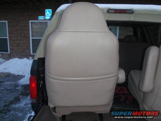 back of a car seat, with another seat to the right. Snow on the ground outside