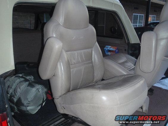 1994 Ford Bronco interior showing tan leather front seats and a sleeping bag in the cargo area