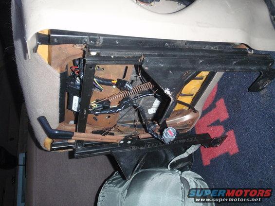 close-up of vehicle seat frame with exposed wiring and connectors