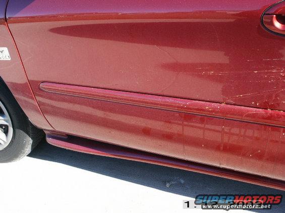 Red 1998 Mercury Sable side view showing door trim and scratches