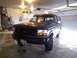 1992 Ford Bronco - A 1992 Ford Bronco is parked inside a garage, showing its front end and side profile.