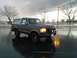 1992 Ford Bronco - 1992 Ford Bronco with a bull bar and auxiliary lights parked outside on a wet day.