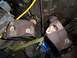 1989 Ford Bronco - Close-up view of two rusty engine parts, possibly cylinder heads or exhaust manifolds.