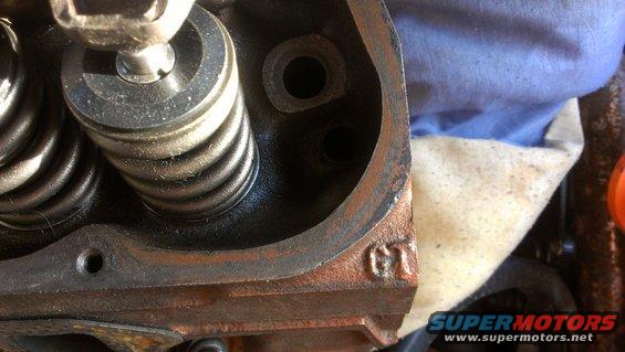 Close-up of engine cylinder head with valve springs and a GT marking
