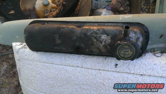 Black engine valve cover with yellow oil cap reading "ENGINE OIL"