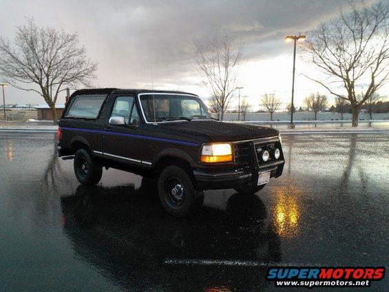 1992 Ford Bronco parked on wet asphalt, front quarter view