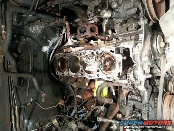 Engine block with cylinders visible, showing internal components and some wear
