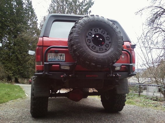 Red Ford Bronco with spare tire mounted on rear carrier. License plate reads GOTFLEX