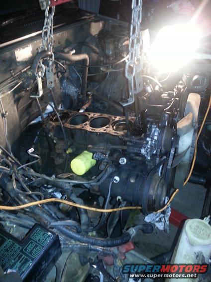 Engine being lifted out of a vehicle with chains