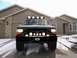 1992 Ford Bronco - This Ford truck features an aftermarket bumper with auxiliary lights and a light bar on the roof.
